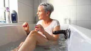 Horny mature mommy with short hair uses dildo on herself while in the bathtub